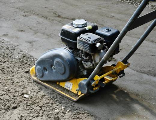 Compacting the base in multiple layers to achieve maximum density and stability.